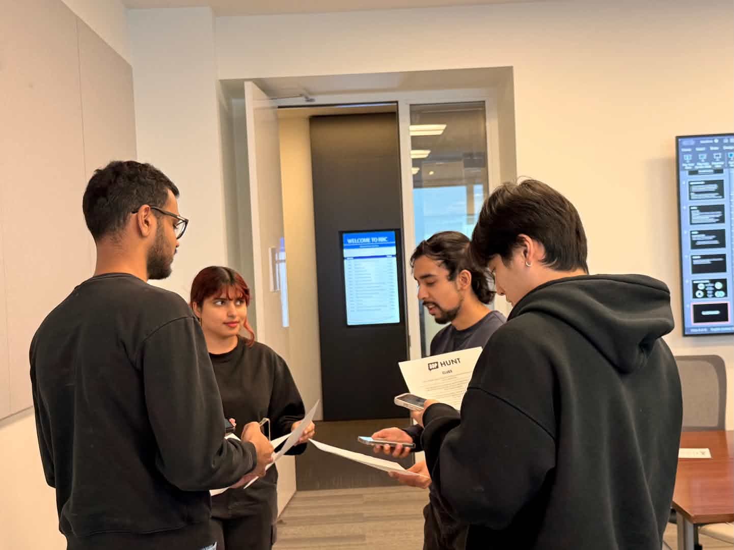 The team reviewing the hunt on printed guides and a screen